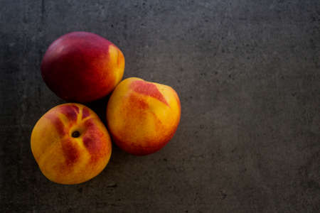 Fresh nectarines close up photo water drops on juicy summer fruits dark grey background healthy eating concept